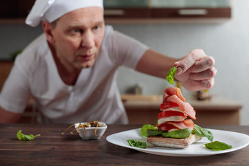 Chef prepares a snack with mozzarella and smoked meat .