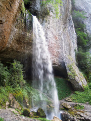 Waterfall high section from top flowing water and rock environement ( hole in rock cliff )