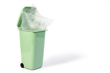Green litter, trash, bin for wet waste or recycling bin with transparency plastic bag on it isolated on white background. Green gabage plastic bins for eco and recycling concept.