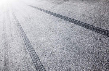 Wheel tracks on the road covered with hoarfrost