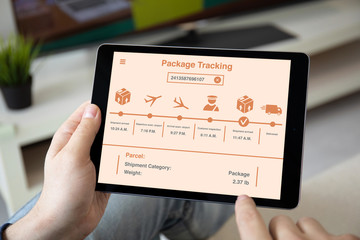 man hands holding computer tablet with app package tracking