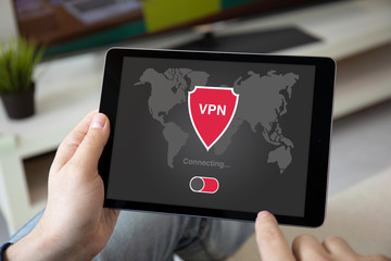 man hands holding computer tablet with app vpn on screen