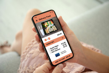 female hands pink dress holding phone with app delivery food