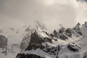 the peaks of the rocks and mountain peaks are covered with white snow against a blue sky....