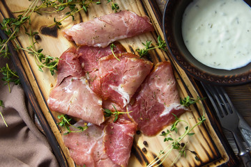 Delicious flavorful ham sliced ​​into strips on a wooden background with spices and fresh thyme. A serving of low-fat succulent farm meat pork. meat product. Food Photography