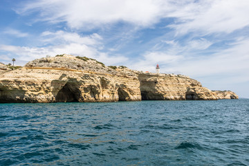 Fototapeta na wymiar Lighthouse on the sea caves in Algarve Portugal