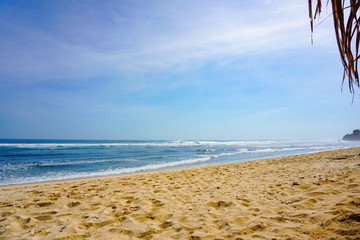 Secluded golden sandy beach, azure ocean water Golden sandy beach Uluwatu, Bali