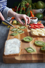 Woman preparing kiwi for sandwiches