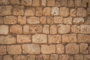 Old beige stone wall background texture close up. Wall from near the sea in the port of Tel Aviv.
