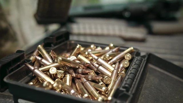 Hands load an assault rifle magazine : clip with bullets, close-up.