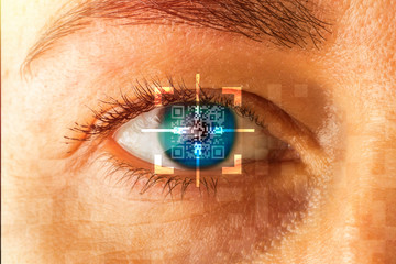 Human eye with glowing lines of QR code. The concept of face recognition, artificial intelligence and the future of high technology. Toned image