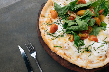 Fresh italian pizza with tomatoes, cheese, basil on black stone background with knife and fork Copy space. Homemade with love. Fast delivery. Recipe and menu. Top view.