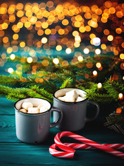 Obraz na płótnie Canvas Hot chocolate with marshmallows on dark green. Christmas festive winter drink background with magic lights