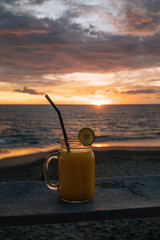 Two colorful fruit shakes on wooden table. Summer and tropical mood. Cold blended drinks, mango and...