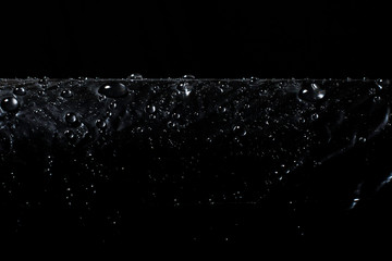 Water drops on a black background. Black polyethylene. Imitation black eco-leather.