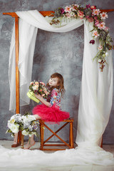 Obraz na płótnie Canvas Girl sitting under weddind decorative arch with flowers