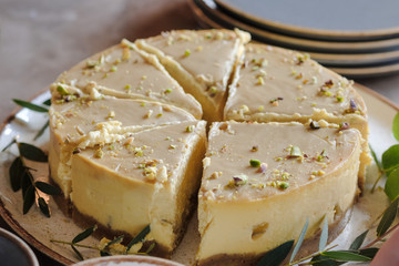 Celebratory Cheesecake on a table in a cafe. Mango and c Pistachios cheesecake. 