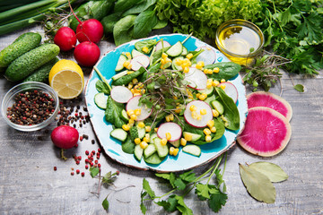 Wholesome vitamin organic vegan food. Salad made from spinach, radish, corn, microgreen, seasoned with olive oil and lemon juice