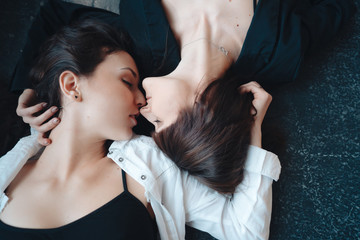 Two beautiful girls lie on the floor