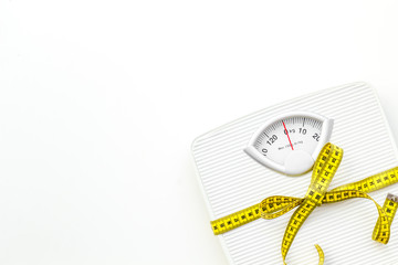 bathroom scales and measuring tape for weight loss concept on white background top view space for text