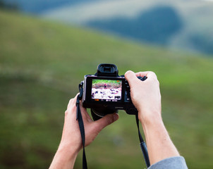 Hands holding the digital photo camera