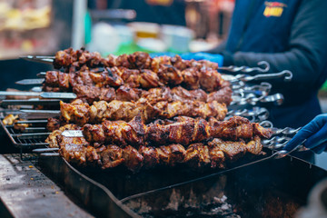 Grilled kebab cooking on metal skewer closeup. Roasted meat cooked at barbecue.
