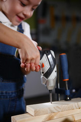 Electric screwdriver or a device for tightening screws in children's hands. Macro photo, out of focus.