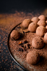 Dark chocolate truffles on black background 