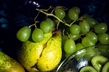 Still life with green and yellow fruit. beautiful fresh fruits in the dark