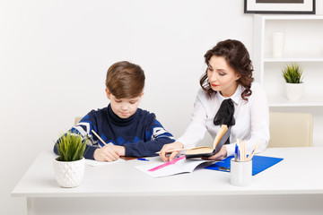 Tutor and student sitting in the white room and doing tasks for lessons.