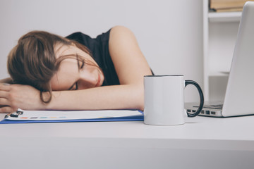 Obraz na płótnie Canvas Overworked woman in office sleeping at her work desk