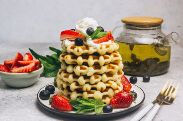 Stack of waffles with blueberries and strawberries