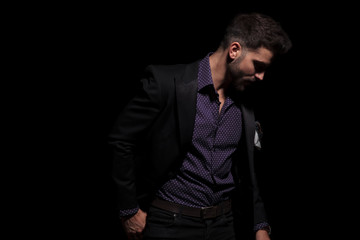 Mysterious guy looking away while wearing a black suit