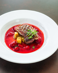 fried duck breast with berry sauce and vegetables (main dish). food background. top
