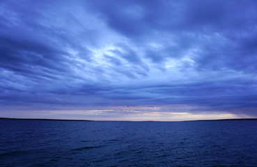 Obraz premium Dramatic sky and sea in dark blue color tone. Seascape horizon after storm