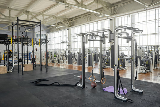 Interior of modern gym with equipment. Gymnastics ring in fitness center. Training accessories in sport club.