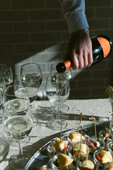 Vertical photo of champagne. The waiter pours champagne in glasses at the celebration. Party and Celebration Concept