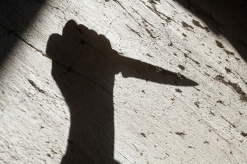Shadow of the hand holding a knife