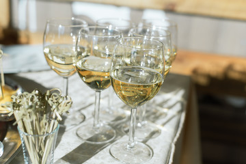 glasses of champagne on the table with a white tablecloth. Celebration and party concept. The buffet table in the sun