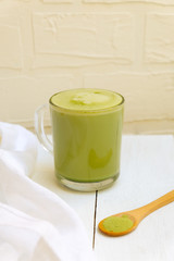 Matcha latte and matcha powder on white background, copy space