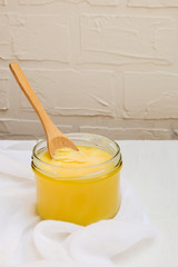 Ghee butter or clarified butter on a table with wooden spoon, top view
