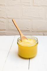 Ghee butter or clarified butter on a table with wooden spoon