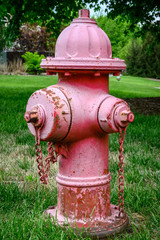 Fototapeta na wymiar An old, forgotten red fire hydrant rusting in the sun.