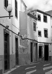 monochrome image of a typical quiet empty street in funchal madeira with old traditional houses...