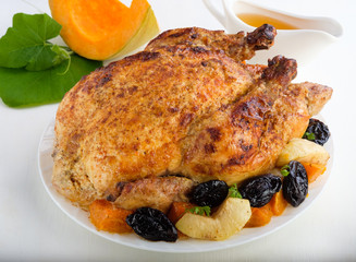 Roast Turkey, chicken, decorated with pumpkins, prunes, apples. thanksgiving day. slow food