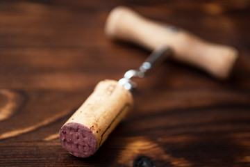 Fototapeta na wymiar Corkscrew and a twisted cork on a wooden background.