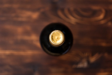 A dark bottle of wine blurry on a wooden background.