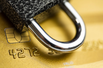 Concept of security payment. Lock on gold credit card.