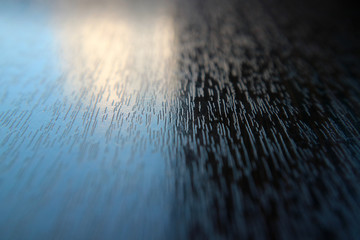 The table surface is wooden textured macro photo of a beam of light as the background.