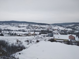 Paisaje de invierno con monta&ntilde;as y &aacute;rboles, casas pueblo rural nieve en Ruman&iacute;a Transilvania